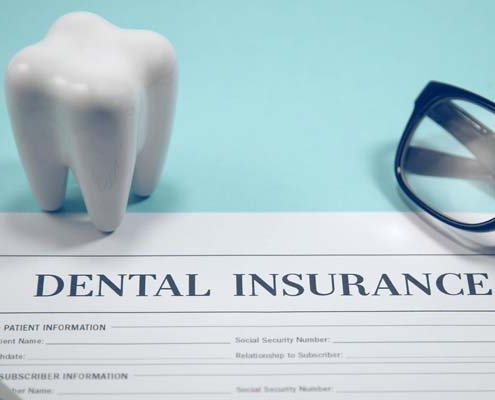 Dental insurance claim form with a tooth model, representing direct billing in Maple Ridge.