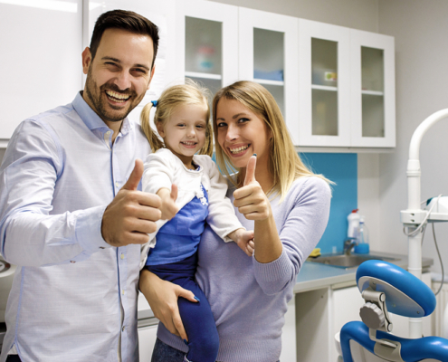 A dentist welcoming a family for a checkup near Langley.