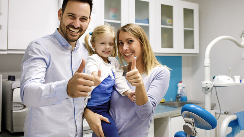 A dentist welcoming a family for a checkup near Langley.
