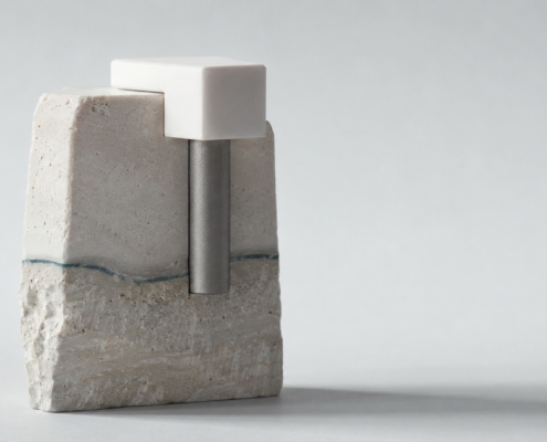 A titanium post anchored into layered stone with a white cap seated on top, representing the surgical and restorative stages of implant treatment.