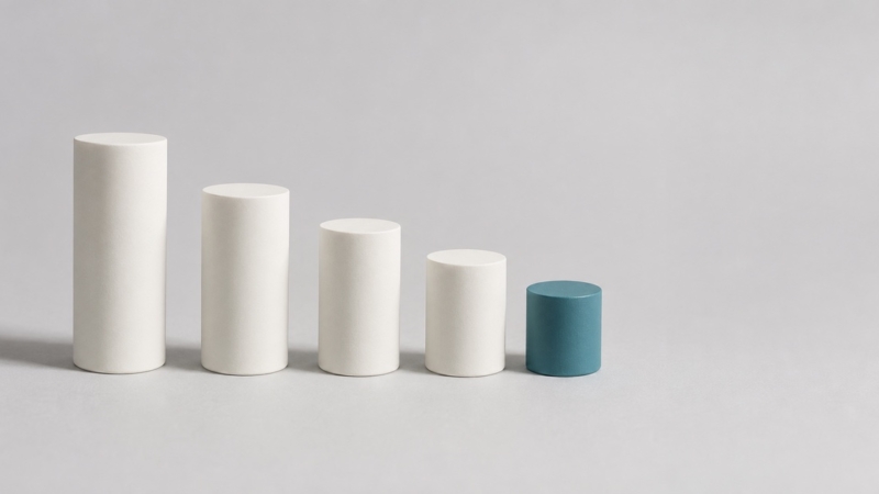 Five ceramic cylinders in a descending row, the smallest in teal, representing the sequential stages of root canal treatment.