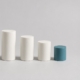 Five ceramic cylinders in a descending row, the smallest in teal, representing the sequential stages of root canal treatment.