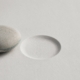A single stone beside an empty indentation of the same size, representing the choice between saving and removing a tooth.