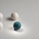 Four spheres with one teal sphere picked out by a circle of light, representing selective monitoring of wisdom teeth.